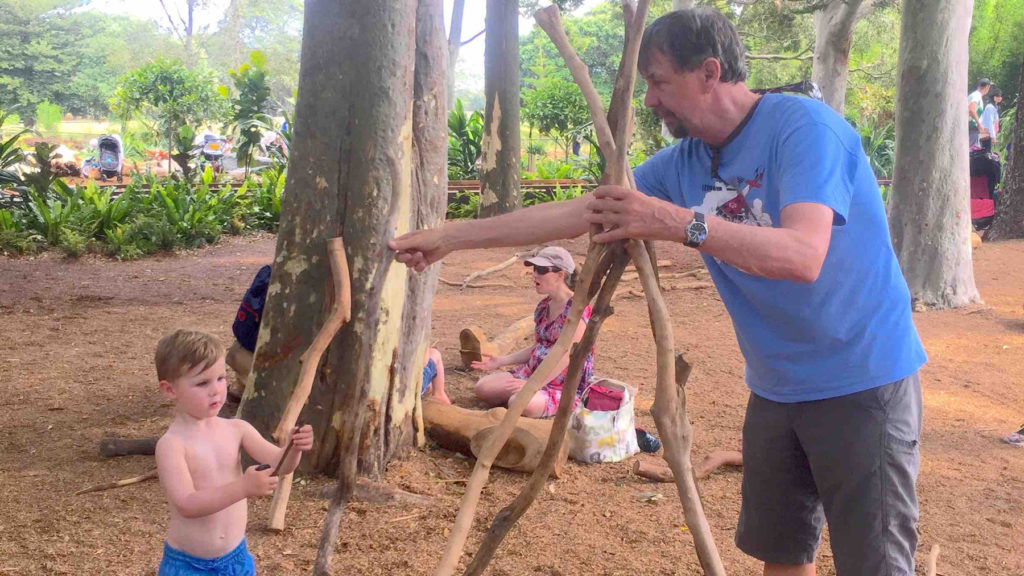 Howard teaching grandson Eden how to make a teepee